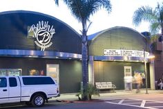 a blurry photo of a building with palm trees in the foreground and a car passing by