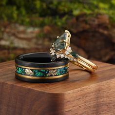 two stacking rings sitting on top of a wooden table next to other jewelry items