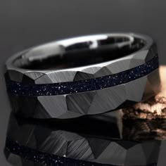 "Blue Goldstone Men's Wedding Band with starry night appearance. Made with black ceramic with faceted / hammered look. It has a strong presence and the sandstone has the appearance of looking deep into space or the night. A very unique men's engagement ring or wedding band Why buy from us? We do our best to make the ring buying process simple and easy for you. With this ring we include: ** Made With Love ** ** Many great 5 star reviews ** ** FREE 1 Year Limited Warranty (See FAQ) ** ** A portion of the sale goes to support charity ** Buy with confidence knowing we will do everything we can to make sure you're happy with the purchase :) // Ring Sizing And Returns // Please double check your ring size before ordering. Please also check if the sizing was done with a comfort fit or standard fi Mens Sapphire Wedding Band, Blue Sandstone Ring, Sandstone Ring, Blue Sandstone, Cute Engagement Rings, Blue Goldstone, Mens Engagement, Unique Wedding Bands, Ring Black