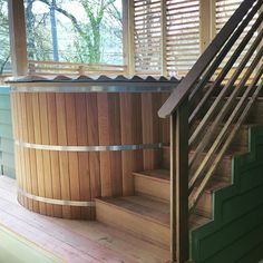 a wooden hot tub sitting on top of a hard wood floor next to a window