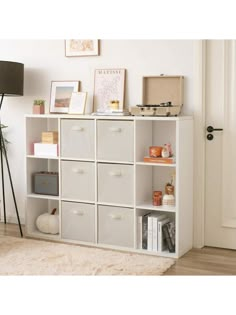 a white bookcase with many drawers in it