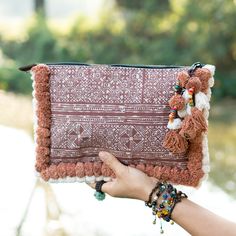 "This beautiful Bag was made by the HMONG hill tribes of Lanna Country (Northern Thailand). It features the edge of bag with two tone pom pom. This bag is zipper closure and one zippered pocket inside. We buy materials from Hmong market and we design and sew by hand. Some of the bags we modify to improve the product. The Hmong tribes live in the North of Thailand and have origins from the Tibetan area of China. Approx Measurement Length: 12\" inches, 30 cm Height: 8\" inches, 20 cm Shipping Orde Bohemian Clutch Bag With Tassels, Bohemian Tassel Clutch Bag, Handmade Bohemian Brown Pouch, Bohemian Handmade Brown Pouch, Bohemian Rectangular Clutch With Tassels, Bohemian Clutch Shoulder Bag With Tassels, Bohemian Tassel Clutch Shoulder Bag, Bohemian Clutch Bag For Daily Use, Bohemian Woven Bags For Festivals