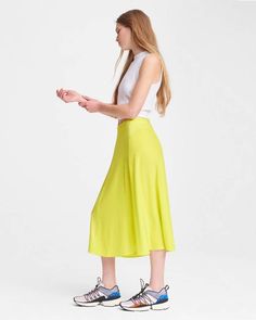 100% silk charmeuse, 100% of your standout looks. The Lucille skirt in lime green is an easy day-to-night midi for summer that will brighten up any warm-weather wardrobe. With a flattering a-line silhouette, it’s fitted at the waist and flares along the knee. Notice the mix of both matte and shine in the silk-among the many intricacies of this hand-selected fabric and expertly executed style. With an invisible zipper at the center back, the mixed-media detailing, and more, this midi takes detail Spring Silk A-line Maxi Skirt, Spring Silk A-line Skirt, Summer Rayon Skirt With Relaxed Fit, Summer Rayon Relaxed Skirt, Relaxed Rayon Summer Skirt, Chic Summer A-line Maxi Skirt, Green A-line Maxi Skirt For Spring, Chic Summer Satin Maxi Skirt, Chic Satin Maxi Skirt For Summer