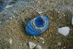 A ring-shaped reef, island, or chain of islands formed of coral The Atoll pendant has been carefully handmade from bonded beach sand, ultramarine or aqua blue resin and metal pigments with a high-gloss polished finish. Two eye screws connect the piece to a fine cable link chain. All metal parts are rhodium plated. Each purchase from BoldB's Aqua Collection will help provide one year of safe water to one person in need through BoldB's support of Water.org, an international nonprofit organisation. Blue Pendant Jewelry For Beach, Unique Gemstone Jewelry For The Beach, Ocean-inspired Blue Pendant Jewelry, Handmade Ocean Color Pendant Jewelry, Handmade Ocean Colored Pendant Jewelry, Blue Gemstone Jewelry For The Beach, Unique Blue Jewelry For The Beach, Handmade Ocean-inspired Resin Jewelry, Blue Ocean-inspired Resin Jewelry