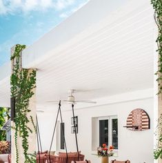 an outdoor dining area with chairs, tables and potted plants on the side wall