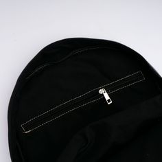 a black round bag with zippers on it