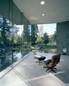 an empty room with glass walls and chairs