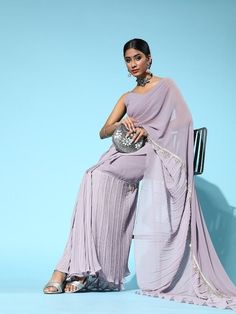 Add this chic and stylish saree to your wardrobe. Designed with a beautiful poly-georgette fabric and solid pattern, it's a striking piece. Elegant lavender hue solid sareePoly-georgettePoly-georgette blouseAccordion pleatedPoly-georgette, dry cleanThe saree comes with an unstitched blouse pieceThe blouse worn by the model might be for modelling purpose only. Check the image of the blouse piece to understand how the actual blouse piece looks like. Size & Fit Length: 5.5 metres plus 0.8 metre blo Elegant Floor-length Chiffon Pre-draped Saree, Floor-length Georgette Palazzo Set With Unstitched Blouse, Semi-stitched Pre-draped Saree In Georgette, Diwali Palazzo Set With Unstitched Blouse In Georgette, Floor-length Chiffon Saree For Party, Elegant Chiffon Sets For Diwali, Festive Floor-length Chiffon Saree, Elegant Floor-length Chiffon Saree, Party Floor-length Chiffon Saree