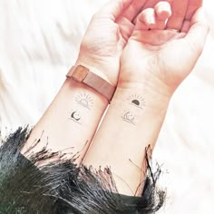 two wrist tattoos with the sun and moon on each one's wrists, both showing their faces