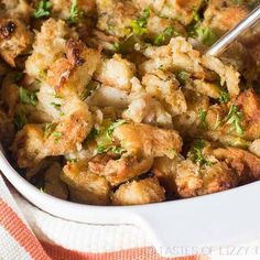 a white dish filled with stuffing and vegetables