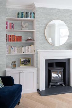 a living room filled with furniture and a fire place in front of a book shelf