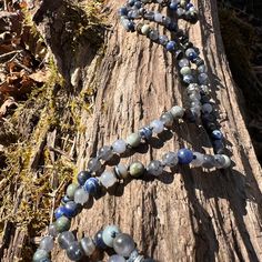 a long beaded necklace on a tree trunk