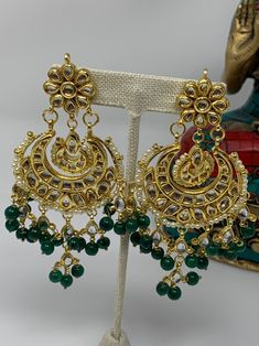 These gorgeous Kundan earrings are featured with amazing combination of Kundan work and green beads.  Made on brass base metal and then gold plated. Approximate length of the earrings is 4 inches and width is ~2inches We carefully inspect each piece before shipping and package in cotton padded box to ensure it arrives safely. All orders are shipped free using USPS, Fedex or UPS.  Please contact with-in 3 days of delivery if you are not satisfied and would like to exchange. Sorry, no returns. Connect with us on Facebook at www.facebook.com/aashi.us to checkout our more designs and see what our customers say about us. Feel free to contact us here on Etsy or at Facebook if you have any question. Traditional Green Beaded Earrings For Party, Traditional Green Beaded Party Earrings, Green Dangle Chandbalis For Festivals, Elegant Green Kundan Chandbalis, Green Tikka With Latkans For Festivals, Green Danglers For Festival Celebrations, Green Danglers For Festivals And Celebrations, Green Danglers For Celebrations And Festivals, Green Danglers For Celebration At Festivals