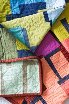 colorful quilts laid out on top of each other with one folded in the middle