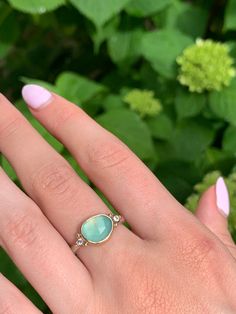 A seafoam green chrysoprase is set in 14k yellow gold a top a sterling silver seagrass band. Accented with small handmade gold beads. Approx stone size: 12mm x 10mm Approx stone weight: 2.9cts Mohs Hardness: 6-7 This one of a kind piece is handmade in Emily's Hudson Valley studio. If you have questions about sizing, shipping or need help deciding please reach out to us! Chalcedony Yellow Gold Jewelry For Anniversary, Yellow Gold Chalcedony Jewelry For Anniversary, Anniversary Yellow Gold Chalcedony Jewelry, Yellow Gold Chalcedony Jewelry With Cabochon, Fine Jewelry In Yellow Gold With Chalcedony, Chalcedony Cabochon Yellow Gold Jewelry, Turquoise Gemstone Ring In Yellow Gold Sterling Silver, Sterling Silver Turquoise Ring With Yellow Gold Gemstone, Sterling Silver Turquoise Ring In Yellow Gold