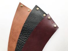 three different colors of leather with rivets on the sides and one black, brown, and tan