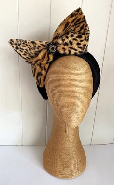 Animal Print Black Brown Bow Headband Fascinator This Animal Print Bowed Headband/Fascinator has been handmade from rayon faux fur & mounted on a hand-covered Black Velvet Headband with a Black/Gold Rhinestone pendant highlight in the center. The Bow itself has been lined with Tulle & slightly stiffened with fabric stiffener & hand-sewn into place giving it this showstopper appearance.  Would make a great Formal or Autumn Racing Day piece. All Pieces are Handmade "one-of-a-kind" Ooak and cannot Fitted Black Novelty Costume Hats And Headpieces, Black Fitted Novelty Costume Hats And Headpieces, Fitted Headband Costume Accessories For Party, Fitted Headband For Party, Fitted Headband For Parties, Black Novelty Cat Ears Headband, Novelty Black Cat Ears Headband, Black Cat Ears Novelty Headband, Novelty Party Hair Accessories With Animal Ears