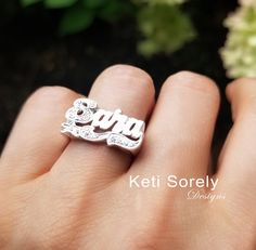 "Personalized name in pretty script font miraculously detailed by our talented jewelers. Amazing custom made jewelry for birthdays, mother's day, Christmas, graduation and etc. Ring will be featured with sparkling Cubic Zirconia stones in first letter and under design. Metal: * Sterling Silver * Sterling Silver with yellow gold overlay * Sterling Silver with rose gold overlay * 10K solid gold (yellow, rose or white gold) * 14K solid gold (yellow, rose or white gold) Sizes - 6 to 10 For larger si Silver Jewelry With Diamond Accents For Birthday, Sterling Silver Jewelry With Diamond Accents For Birthday, Anniversary Cubic Zirconia Nameplate Jewelry, Personalized Cubic Zirconia Engraved Wedding Ring, Personalized Silver Engraved Ring With Cubic Zirconia, Customizable Cubic Zirconia Jewelry For Anniversary, Personalized Cubic Zirconia Rings For Birthday, Engraved Cubic Zirconia Jewelry For Anniversary, Personalized Silver Engraved Ring For Mother's Day