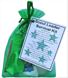 the scout's survival kit is packed in a green organine bag and tied with ribbon