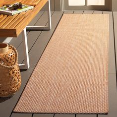 an outdoor area rug is shown on the floor next to a wooden bench and door