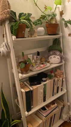 there is a shelf with books and plants on it