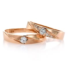 two gold wedding rings with diamonds on them