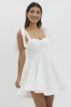 Stunning details in this chic and trendy dress perfect for Summer, Brides, Graduations, Bachelorette Parties, White Parties, vacations, and so much more! Our Follow Your Dreams White Mini Dress features a fit and flare skirt, self tie bow straps, eyelet details, corset top, padded bust, back zipper, and is fully lined. 100% Cotton. Model Measurements: Height 5'5", Bust 33", Waist 25", Hips 33" wearing a size Small. Summer A-line Mini Dress With Tie Straps, Chic A-line Dress With Tie Fastening, Elegant A-line Sundress With Tie Back, Spring A-line Mini Dress With Bow Straps, Chic Mini Dress With Sweetheart Neckline And Tie Back, A-line Mini Dress With Tie Back For Beach, Beach Dress With Tie Back And Sweetheart Neckline, Flirty A-line Mini Dress With Tie Back, Summer Party Dress With Tie Straps