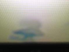 a blurry image of a blue object on a monitor screen with the light coming from behind it