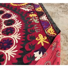 a large red and black rug on the ground with an intricately designed design in it