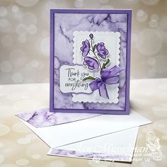 a close up of a card with purple flowers on the front and back of it