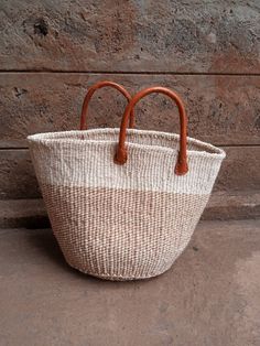 "This crescent shaped, short strap handbag is made of sustainably-sourced sisal fiber. Its perfect as a shopping/market, beach or summer bag. It's durable as the fibres used are all natural. It has short leather straps that can be easily swapped for long leather straps to be carried as a shoulder bag or cross-body bag. DIMENSIONS Bottom width: 12\" Top width: 16\" Depth: 12\" Straps: 5\" SHIPPING All orders ship via DHL Express (3-5) days delivery time." Handmade Neutral Tote Bag, Eco-friendly Beige Beach Bag With Rolled Handles, Beige Bucket Bag For Market, White Handwoven Straw Bag For Everyday, White Jute Bag With Leather Handles, Eco-friendly Straw Bag With Rolled Handles, White Jute Bags With Leather Handles, Large Natural Straw Bag, Eco-friendly Handwoven Cream Bag