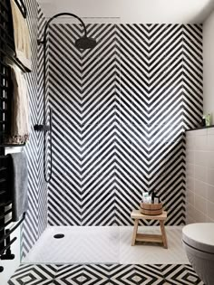 a bathroom with black and white tiles on the wall