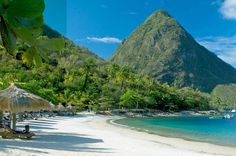 the beach is lined with palm trees and umbrellas