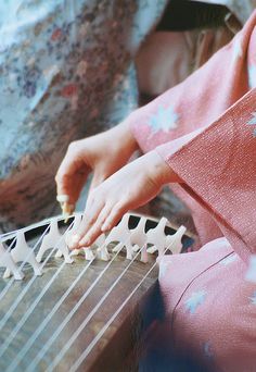 a woman is playing an instrument with her hands