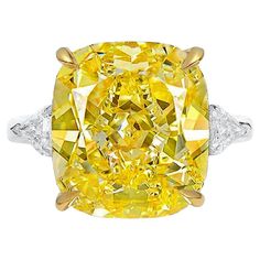 a fancy yellow diamond ring with diamonds around it