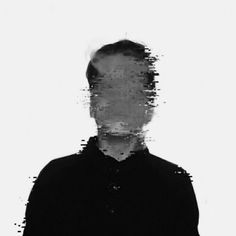 a man standing in front of a white background with black and grey paint splatters