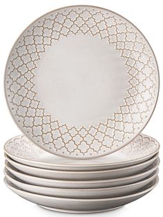 six white plates stacked on top of each other in front of a white background with gold trim