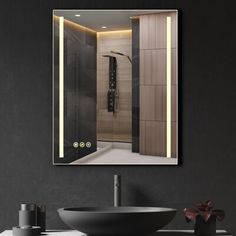 a bathroom with a sink, mirror and lights on the wall next to black walls