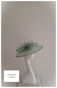 Grace and glamour hatinator in Pistachio green sinamay.  A crisp gentle curved brim is complemented with a low crown, which has been embellished with green pearls.  A sinamay bow plays host to a green starburst feather flower, whilst a pair of ostrich quills add a little drama.  Sits on a headband.  This item has sold, however, similar pieces can be made in a variety of colours.  Please ask for details.  As every piece is handmade, some differences can occur from the photos listed on this site. Elegant Green Headpiece For Church, Elegant Green Fascinator For Church, Green Headpiece For Wedding And Kentucky Derby, Green Headpiece For Church And Royal Ascot, Elegant Green Top Hat For Party, Elegant Green Church Fascinator, Green Formal Hat Headpiece, Elegant Green Costume Hats And Headpieces For Church, Adjustable Green Mini Hat For Wedding