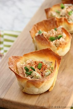 small appetizers are lined up on a cutting board