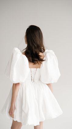 the back of a woman wearing a white dress