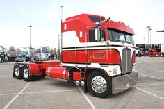 a red semi truck parked in a parking lot