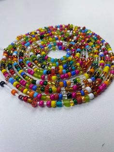 Brighten your life and wardrobe with our stunning Multicolored Waistbead. Handcrafted with love, each bead is carefully selected and strung to create a vibrant, eye-catching accessory that complements any outfit. Uses of the Multicolored Waistbead: • Fashion Statement: Wear it over or under your clothing to add a pop of color and a touch of elegance to your ensemble. • Body Awareness: Helps you stay mindful of your body, serving as a gentle reminder of your fitness and wellness journey. • Weight Multicolor Round Waist Beads For Beach, Multicolor Waist Beads For The Beach, Multicolor Waist Beads For Beach, Multicolor Beaded Chain Waist Beads For Festivals, Spiritual Multicolor Waist Beads With Tiny Beads, Multicolor Heart Beads Jewelry For Party, Adjustable Multicolor Beaded Chain Waist Beads, Adjustable Multicolor Waist Beads With Large Beads, Adjustable Multicolor Festival Beads