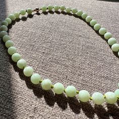 "The \"Imperial Long Jade Necklace\" has 42, 100% pure, Grade-A Jadeite (10mm each) beads; each handpicked and cut by our finest gemologists to create the best, purest necklace. Our long edition shows off each individual bead, showing each ones' similarities and differences. We allow the Jadeite to shine with handcrafted green knots to separate the beads, and seal the story with our signature Gold Clasp. Materials: 0.60g 14K Gold, 42 Grade-A Untreated natural calibrated 10mm Jadeite beads Dimens Jade Gemstone Beaded Necklace With Round Beads, Jade Gemstone Beaded Necklaces With Round Beads, Healing Single Strand Round Bead Gemstones, Elegant Jade Beads For Jewelry Making, Jade Beaded Necklace With Gemstone Beads, Jade Beaded Necklaces With Gemstone Beads, Beaded Jade Necklaces With Gemstone Beads, Elegant Faceted Round Bead Gemstones, Elegant Jade Gemstone Beads