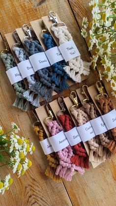 several different colors of tassels are on the table next to flowers and scissors