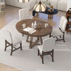 a dining room table with chairs around it and a rug on the floor next to it