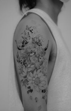 a black and white photo of a woman's arm with an animal tattoo on it