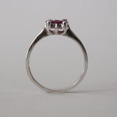 This piece is a wonderful solid white gold ring. It is also a new vintage- made before 2001. The ring is brilliantly decorated with 4 genuine princess cut Chantaburi rubies from Thailand in the middle and on the sides are 4 tiny round cut natural diamond. Only one left- once its gone its gone! Product Details: Metal: 18k Solid Gold Metal Color: White Gold Gold weight: 3.10 grams Ruby: Natural, princess cut, 0.65 carats Diamonds: Natural, round faceted cut, 0.08 carats Band Width: 7 mm #Customiza Classic Promise Birthstone Ring With Polished Finish, Hallmarked Vintage White Gold Ruby Ring, Vintage Hallmarked White Gold Ruby Ring, Vintage White Gold Birthstone Ring, Classic Sapphire Promise Ring, Classic White Gold Birthstone Promise Ring, Formal White Gold Birthstone Ring With Polished Finish, Classic Brilliant Cut Round Amethyst Ring, Classic Heart Ring With Brilliant Cut For Formal Occasions