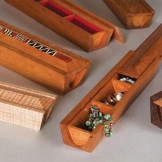 several wooden boxes with jewelry in them sitting on a table next to some other items