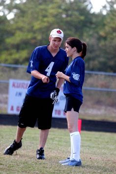 a man and woman standing next to each other on a field